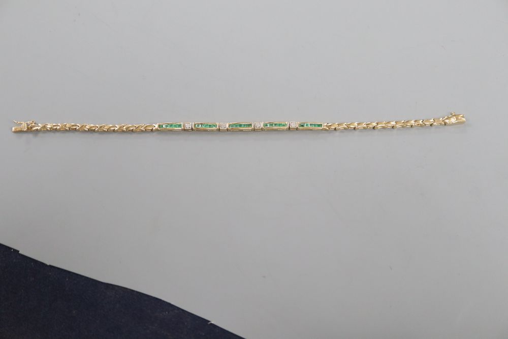 A modern 375 yellow metal, emerald and diamond chip set line bracelet, 18.2cm, gross 7.5 grams.